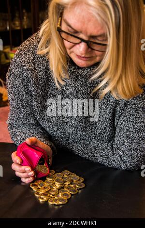 Frau mit einem Stapel von £1 Münzen. Stockfoto