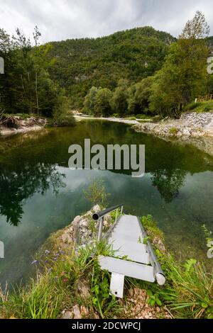 Steile Metalltreppe führt hinunter zu einem kleinen Fluss mit weiß Rundsteine am Ufer des Triglav Nationalparks In Slowenien am bewölkten Herbsttag Stockfoto