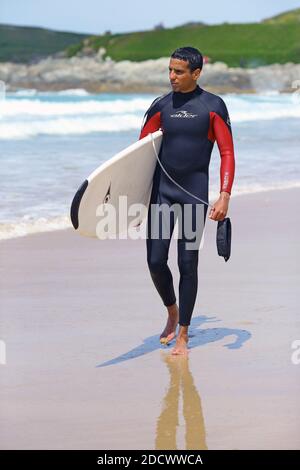 Männlicher Surfer am Fistral Beach in Newquay, Cornwall, England Stockfoto