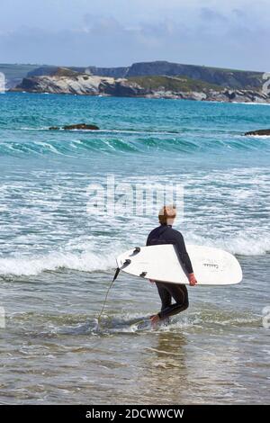 Surfer, der am Great Western Beach in Newquay, Cornwall, England ins Meer kommt Stockfoto