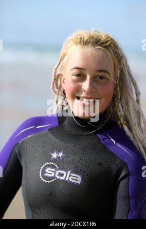 Porträt einer glücklichen Surferin mit Dreadlocks am Fistral Beach in Newquay, Cornwall, England Stockfoto