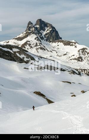 Person Wandern mit Midi d'Ossau Südseite Gipfelblick aus Aneou Zirkus, Pyrenäen Nationalpark, Frankreich Stockfoto