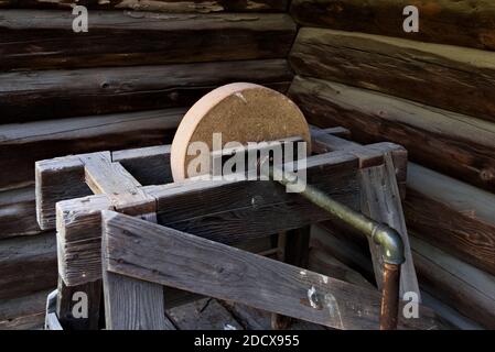 Antiker Schleifstein aus Holz, Eisen und Stein, zum Schärfen von Messern und anderen Metallwerkzeugen. Stockfoto