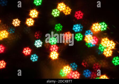 Weihnachten festliche Hintergrund. Verschwommener Weihnachtshintergrund, festliche Weihnachten mehrfarbige Bokeh Hintergrund in Form der Schneeflocken Stockfoto