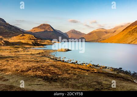 Goldenes Abendlicht am Wasser im Lake District mit Berggipfeln. Stockfoto