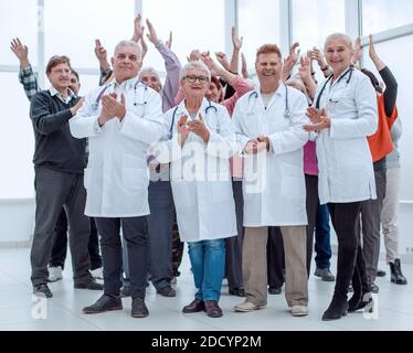 Ärzte und eine Gruppe reifer Menschen applaudieren Stockfoto