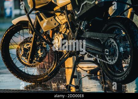 Waschserie für Motorräder. Ein Motorrad bei einer Autowäsche bei Sonnenuntergang waschen. Stockfoto