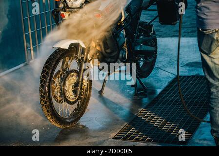 Waschserie für Motorräder. Ein Motorrad bei einer Autowäsche bei Sonnenuntergang waschen. Stockfoto