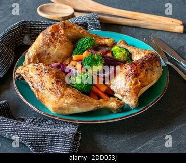 Gesunde Hähnchengericht mit Backofen gebratenen Hähnchenschenkel und Gemüse auf einem Teller serviert. Low in Kohlenhydraten Mahlzeit Stockfoto