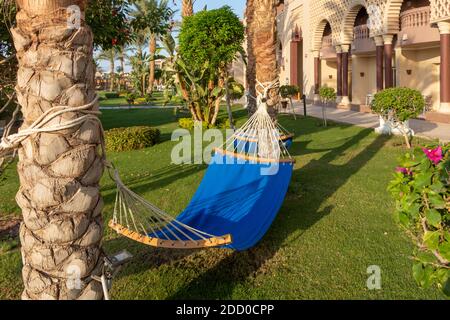 Hurghada, Ägypten - September 25 2020: Hängematten zwischen zwei Palmen im ägyptischen Garten. Urlaubs- und Urlaubskonzept Stockfoto