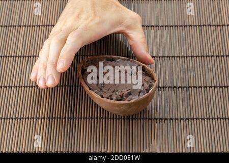 Die rechte Hand eines Erwachsenen nimmt das Schokoladenösterei auf (Foto 2). Stockfoto
