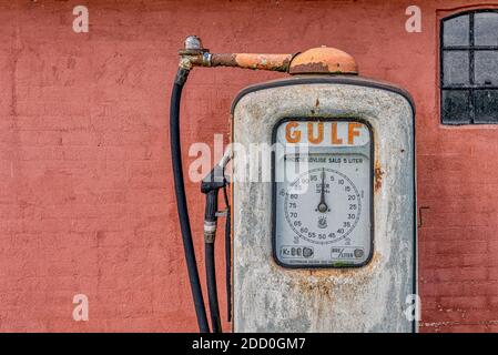 Eine verrostete Gaspumpe für Gulf Benzin gegen eine rot lackierte Ziegelmauer, Holl, Dänemark, 15. November 2020 Stockfoto