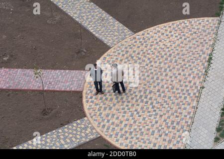 Tiraspol, Moldawien - 22. April 2020: Zwei Männer sprechen auf der Straße ohne Schutzmasken und ohne Rücksicht auf soziale Distanz während der Pandemie. Stockfoto