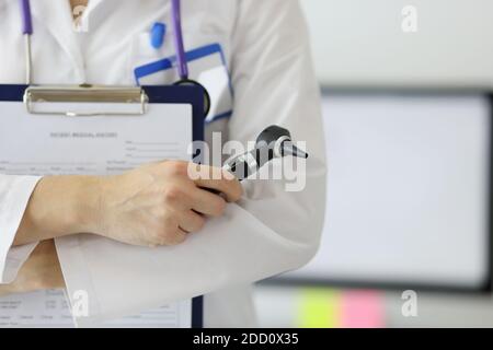 Der Otolaryngologe hält ein Otoskop in den Händen. Stockfoto