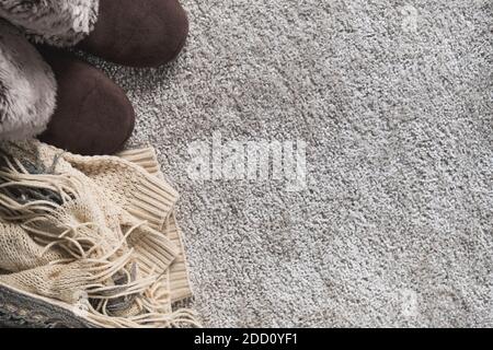 Gemütlicher Winterhintergrund mit warmer Kleidung in beige Farbe. Pullover, Schal und Hausschuhe im skandinavischen Stil. Flach liegend, Draufsicht Stockfoto