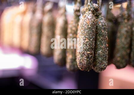 Katalanische Trockenwürste mit verschwommenem Hintergrund, auf dem Lebensmittelmarkt in Barcelona Stockfoto