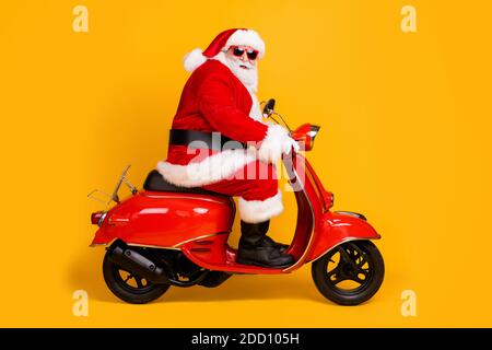 Profil Seitenansicht seiner er schön lustig dick Weißhaarige Santa Reiten Motorrad Reise-Reise-Rout Eve Noel Besuchen Sie Shopping Verkauf isoliert hell Stockfoto