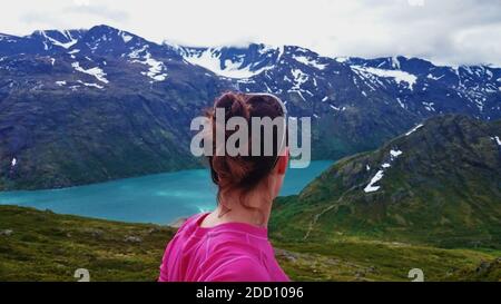 Wanderweibchen, die bei einer Sommerwanderung über einen spektakulären Blick auf einen norwegischen Fjord blicken. Stockfoto