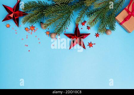 Einrichtung mit Fichtenzweig und roten Weihnachtsdekor auf blauem Hintergrund Stockfoto