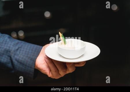 Hand in einem Anzug hält Zitronensorbet. Stockfoto