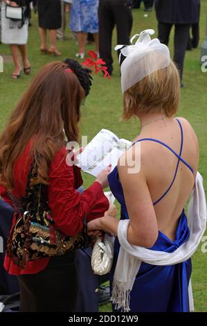 Zwei kaukasische Damen untersuchen die Form der Pferde, Glorious Goodwood Ladies' Day, 2. August 2007. Stockfoto