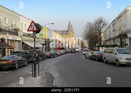 London, Großbritannien - 09. Januar 2010: Westbourne Grove West End London Street mit geparkten Autos, bunten Fassadenhäusern und Menschen, die durch Shopping in Stockfoto