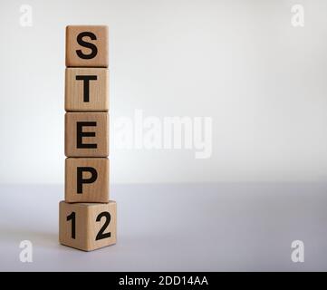 Schritt für Schritt. Zeit bis zu Schritt 2. Einen Würfel gedreht und den Ausdruck 'step 1' in 'step 2' geändert. Schöner weißer Hintergrund. Geschäft und nächster Schritt concep Stockfoto