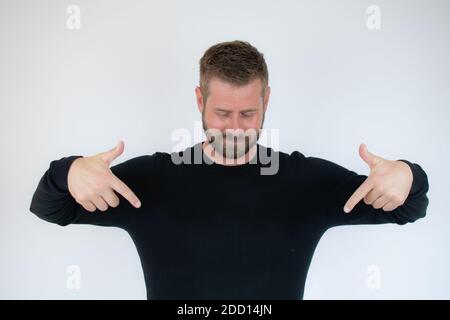 Junger kaukasischer Mann posiert isolierte Punkte mit Fingern nach unten, positives Gefühl. Stockfoto