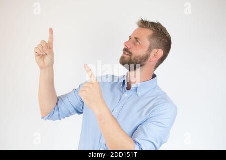 Schöner bärtiger Mann in lässiger Kleidung zeigt weg, auf weißem Hintergrund Stockfoto