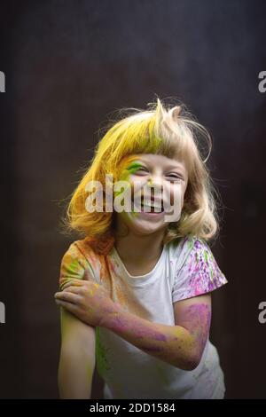 Kleine lustige Mädchen mit Holi Farben spielen. Stockfoto