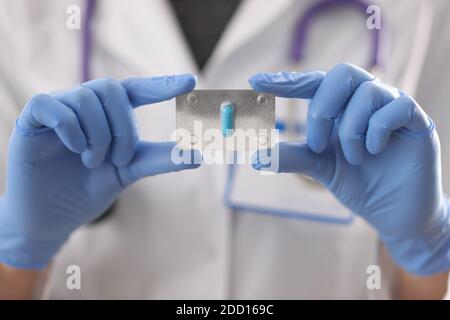 Arzt in Gummihandschuhe halten Blister blaue Kapsel Nahaufnahme Stockfoto