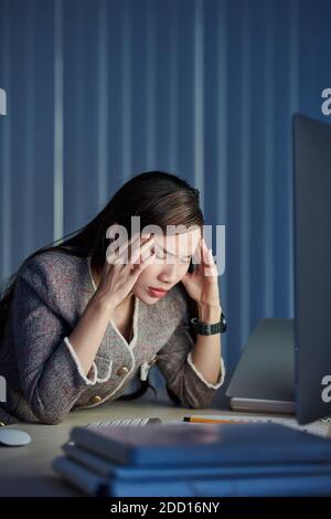 Geschäftsfrau, die unter Kopfschmerzen leiden Stockfoto