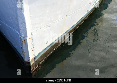 Bug aus weißem Holzboot sitzt auf seinen Liegeplätzen auf dem Dock. Stockfoto