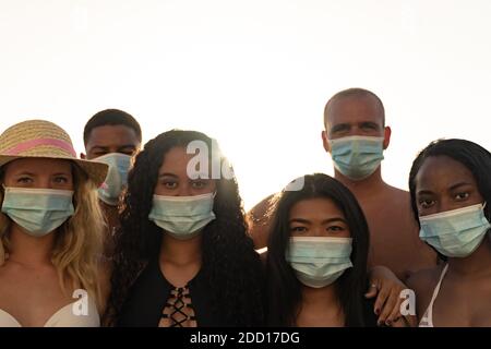Touristen aus verschiedenen Kulturen und Rassen mit Blick auf die Kamera. Junge Menschen mit Schutzmaske für Coronavirus. Covid 19 und Freundschaftskonzept. Stockfoto
