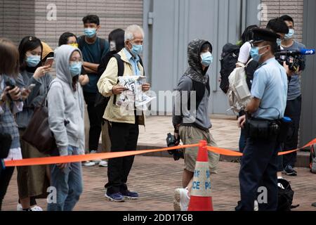 Hongkong, China. November 2020. Opa Chan, Unterstützer der Aktivisten Joshua Wong, Agnes Chow und Ivan Lam, die eine Zeitung halten, lauteten vor den Gerichten der West-Kowloon-Magistraten "hängen da drin", nachdem Joshua Wong, Agnes Chow und Ivan Lam am am Montag, den 23. November 2020 in Hongkong, China, einen Schuldspruch eintraten. Stockfoto