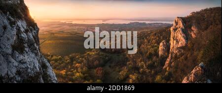 Farbenprächtiger Herbstuntergang über Weinbergen und Wald vom Rocky Hill aus gesehen im Palava-Schutzgebiet bei Mikulov in Südmähren, Tschechische Republik Stockfoto