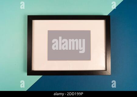 Leerer schwarzer Fotorahmen auf farbigem Hintergrund. Stockfoto