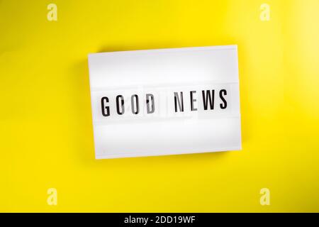 Guter Nachrichtensext auf Leuchtkasten auf gelbem Hintergrund isoliert Draufsicht, flach liegend Stockfoto