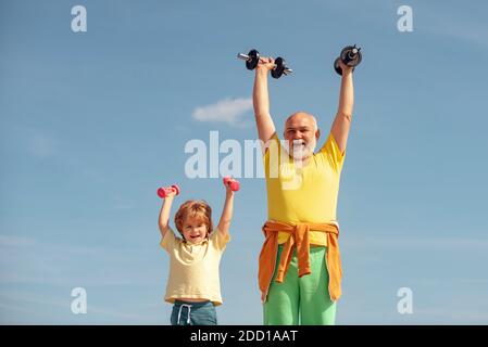 Portrait von älteren Mann und niedlichen Kind Hanteln heben. Kind, das eine Hantel hebt. Älterer Mann und Kind im Familiengesundheitsclub. Ich liebe Sport. Sport für Stockfoto