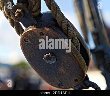 Gebrauchte Holzrolle mit Seilen, zum Heben von Segeln auf einem hohen Schiff verwendet. Stockfoto