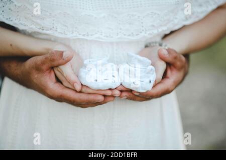 Das Brautpaar hält die Kindersocken in den Händen Stockfoto