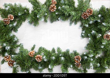 Weihnachtsbaum Girlande umrahmt den Raum für die Inschrift auf einem Zement Hintergrund, Copy Space Stockfoto