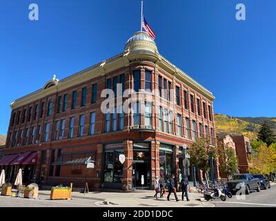 Aspen, CO / USA - 28. September 2020: Aspen Elks Lodge Gebäude mit Einheimischen im Vordergrund und Herbstfarben Berge und Bäume im Hintergrund Stockfoto