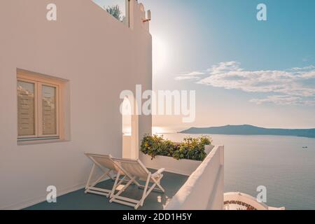 Zwei Liegestühle auf dem Dach. Schöne Terrasse mit Meerblick, fantastische Sonnenuntergangslandschaft, Stühle für Paare. Romantischer Blick auf den Sonnenuntergang, Sommerurlaub Stockfoto