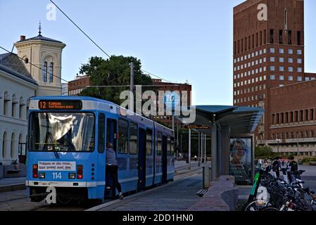 Oslo, Norwegen - 29. August 2020: Stadtbahn an einer Haltestelle in Oslo, Rathaus im Hintergrund. Stockfoto