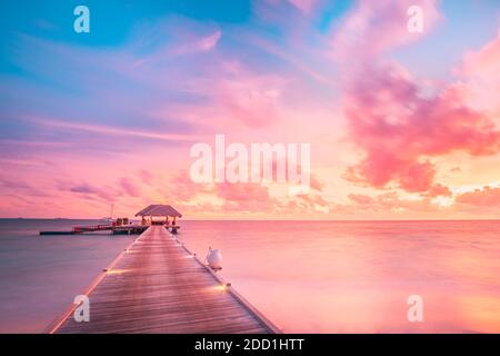 Sonnenuntergang Himmel und Reflexion über das ruhige Meer, Malediven Strand Landschaft von Luxus über Wasser Bungalows. Exotische Landschaft von Sommer und Urlaub Stockfoto