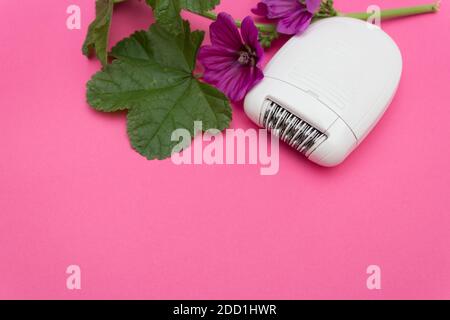 Epilierer für Haare auf rosa Hintergrund. Schönheitskonzept. Speicherplatz kopieren Stockfoto