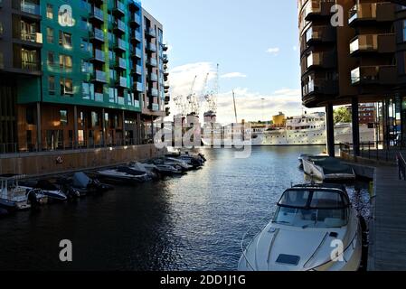 Oslo, Norwegen - 29. August 2020: Apartments am Wasser an einem Kanal mit der norwegischen königlichen Yacht im Hintergrund. Stockfoto