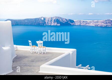Minimalistische Reiselandschaft mit Stühlen und weißer Architektur in Santorini. Luxusurlaub im Sommer, Urlaub für Paare. Meerblick, romantische Stimmung, entspannen Stockfoto