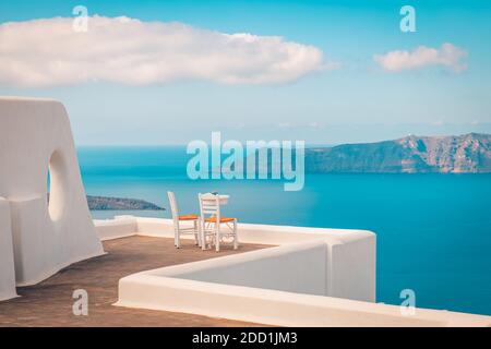 Minimalistische Reiselandschaft mit Stühlen und weißer Architektur in Santorini. Luxusurlaub im Sommer, Urlaub für Paare. Meerblick, romantische Stimmung, entspannen Stockfoto